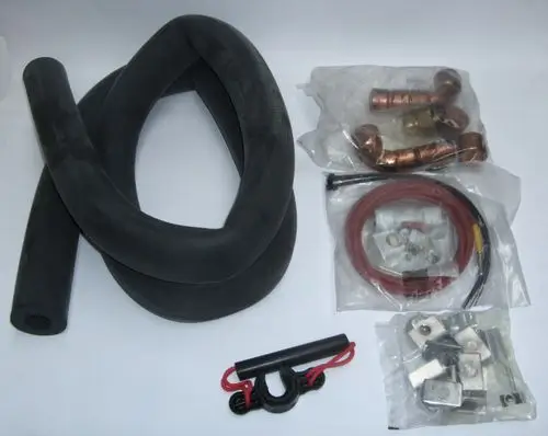 Daikin Anschluss-Set mit flexiblen schwarzen Rohren, Kupferfittings, Schlauchleitungen und Zubehörteilen in durchsichtigen Verpackungen, angeordnet auf weißem Hintergrund.